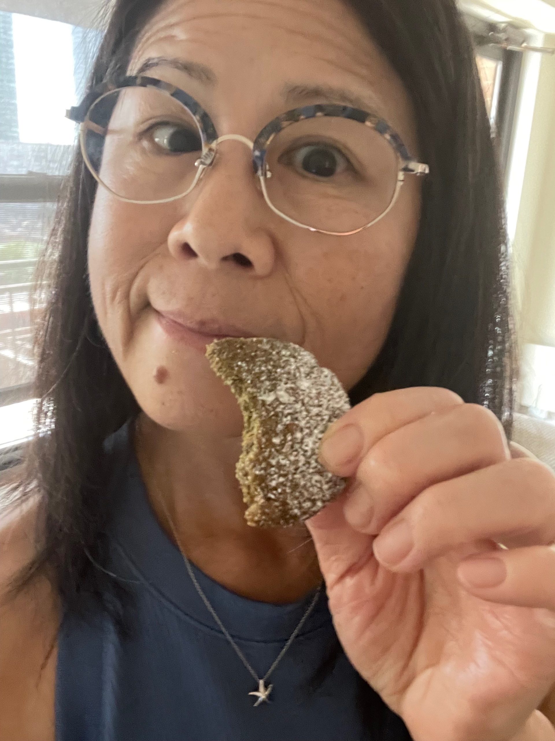 Image of owner Susan Wong eating a tumeric black pepper ginger shortie cookie.