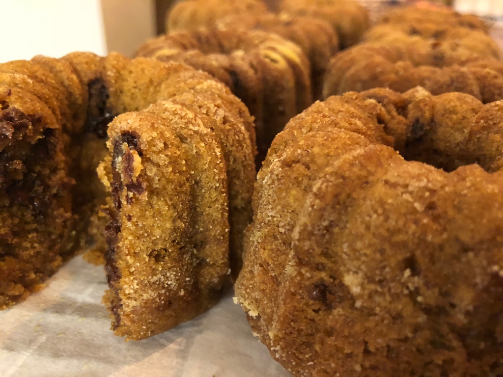 Several banana mini bundt cakes on a wooden board.