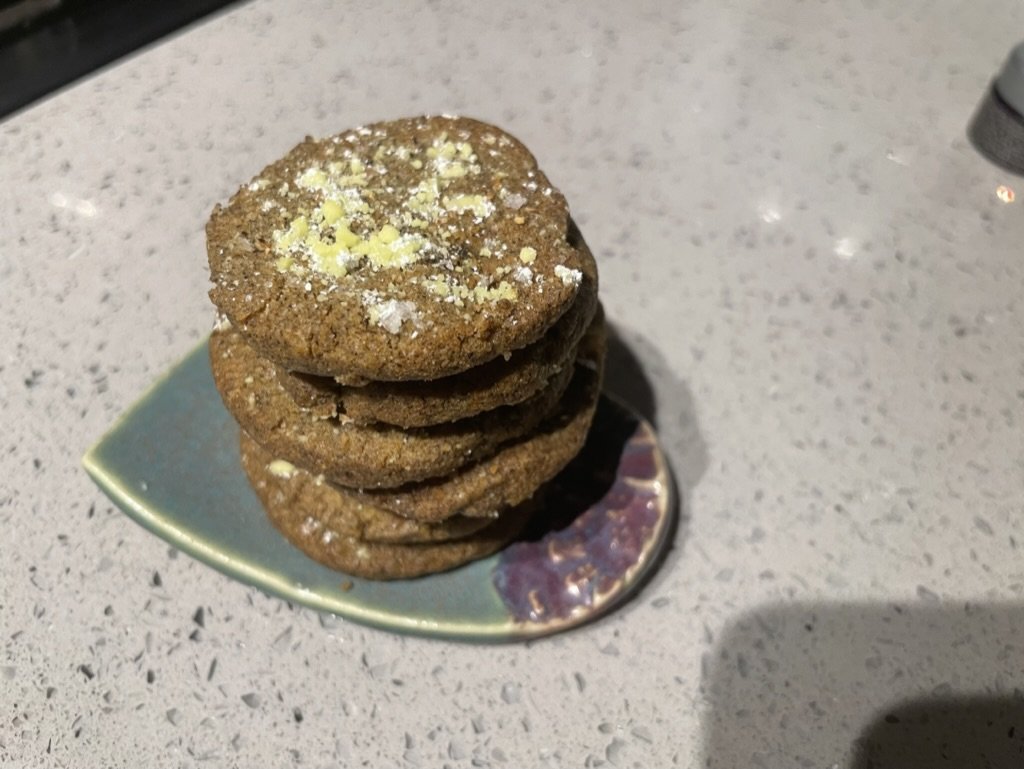 Tumeric black pepper ginger shorties stacked 5 high on a small green and viotel dish.